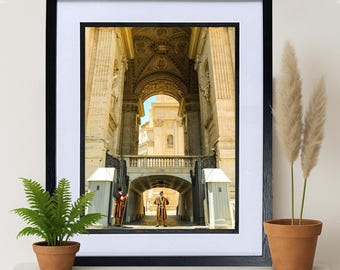 Puede incluir: Una fotografía enmarcada de una gran entrada arqueada a un edificio. Dos figuras con uniformes tradicionales y coloridos hacen guardia en la entrada. El interior del edificio es visible a través del arco, revelando un techo abovedado y detalles ornamentados.