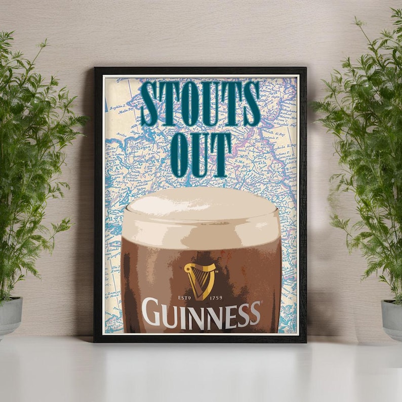 Puede incluir: Impresi&oacute;n enmarcada de una pinta de Guinness stout con una cabeza cremosa. Las palabras "STOUTS OUT" est&aacute;n en verde azulado sobre la pinta. El logotipo de Guinness es visible. El fondo es un mapa.