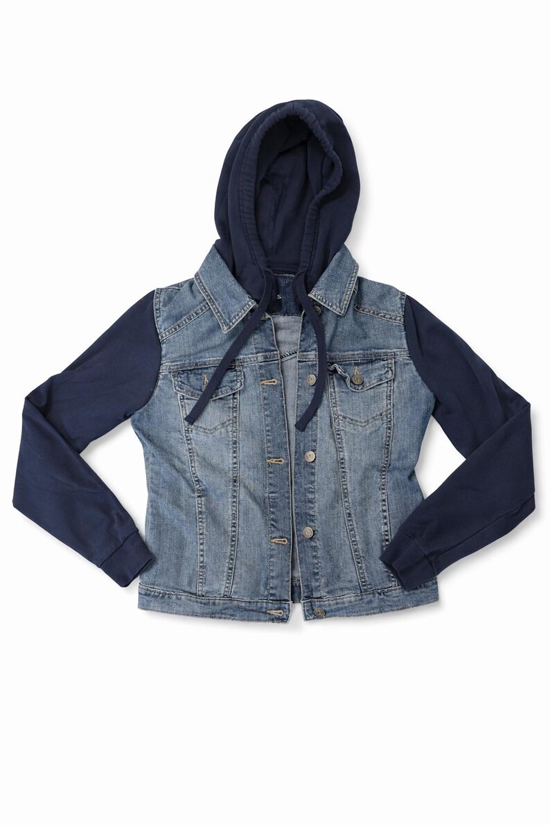 Pode incluir: Casaco de ganga azul claro com capuz e mangas azul marinho. O casaco tem fecho de bot&otilde;es, dois bolsos no peito e um cord&atilde;o no capuz. As mangas e o capuz s&atilde;o azul marinho liso.