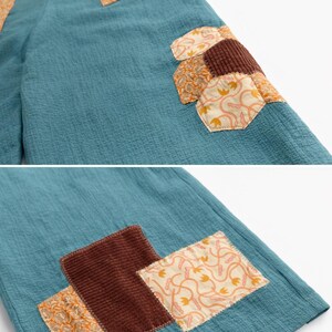Puede incluir: Pantalones de color turquesa con parches decorativos en tonos marr&oacute;n y naranja. Los parches presentan varios patrones y texturas, incluyendo pana y dise&ntilde;os florales. Las letras "BMFS" est&aacute;n bordadas en la cintura.