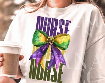 May include: A white t-shirt with the text "NURSE LIFE NURSE" in green, purple, and gold lettering. A purple, gold, and green bow with a fleur-de-lis in the center is between the words "NURSE" and "LIFE".