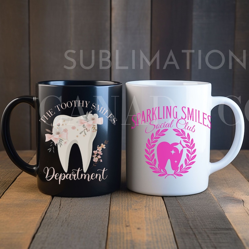 May include: Two ceramic mugs with different designs. The black mug has a white tooth with pink flowers and the text "The Toothy Smiles Department". The white mug has a pink tooth with a star and a wreath around it and the text "Sparkling Smiles Social Club".