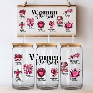 Pode incluir: Três copos de vidro transparente com tampas de madeira e canudos, cada um com as palavras "Women of the Bible" e ilustrações. Uma placa de madeira acima exibe o mesmo tema. As ilustrações incluem uma cruz, mãos em oração e um coração.