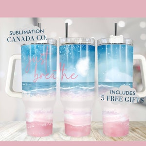 May include: A stainless steel tumbler with a white handle and a pink and blue watercolor design featuring ocean waves and the text "just breathe".