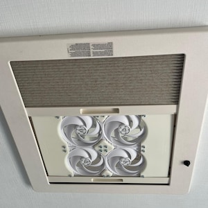 Könnte beinhalten: Ein weißer Deckenlüfter mit vier weißen Ventilatoren. Der Lüfter ist geöffnet und die Ventilatoren sind sichtbar. Der Lüfter ist an einer weißen Decke montiert.