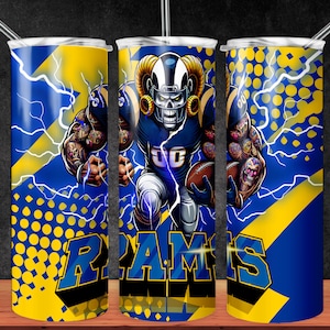 May include: A blue and yellow tumbler with a graphic of a football player wearing a helmet with horns and the word "RAMS" on it. The background has a yellow and blue polka dot pattern and lightning bolts.
