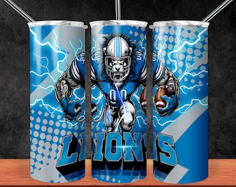 May include: A blue and white stainless steel tumbler with a graphic of a football player wearing a helmet and holding a football. The graphic is surrounded by lightning bolts and the word "LIONS" is printed on the tumbler.