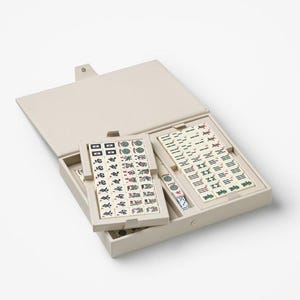 Puede incluir: Un juego de Mahjong beige con fichas dispuestas dentro de un estuche a juego. El estuche est&aacute; abierto, revelando las fichas con varios s&iacute;mbolos y caracteres. El juego incluye dados y est&aacute; dise&ntilde;ado para el cl&aacute;sico juego de fichas.
