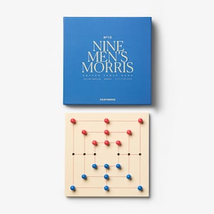 May include: A blue box and a Nine Men's Morris game board. The box has the game title in gold lettering. The game board is beige with red and blue pegs. The game is a coffee table game.