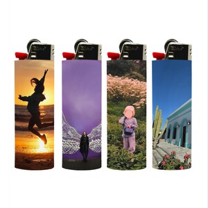 Puede incluir: Cuatro encendedores con diferentes dise&ntilde;os. Uno muestra a una persona saltando al atardecer, otro presenta a una persona con alas de &aacute;ngel, un tercero tiene un ni&ntilde;o en un campo y el &uacute;ltimo representa un edificio con cactus.