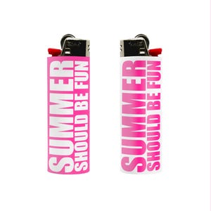 May include: Two lighters with the text "SUMMER SHOULD BE FUN" in white on a pink background. One lighter has a pink body, and the other has a white body. Both lighters have a black top with a red ignition button.