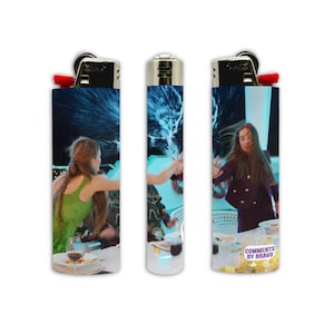 May include: Set of three lighters with a vibrant design. Each lighter features a different scene with people and a splash of liquid. One lighter has the text "COMMENTS BY BRAVO".