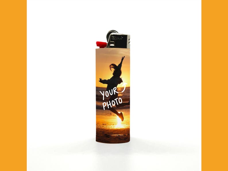 Puede incluir: Un encendedor personalizado con la parte superior negra y un bot&oacute;n de encendido rojo. El cuerpo presenta una silueta de una persona saltando al atardecer, con el texto "YOUR PHOTO" en blanco.