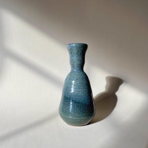 May include: A small, blue and green ceramic vase with a speckled glaze.