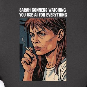 May include: Dark gray t-shirt featuring a pop art style illustration of a woman smoking a cigarette. The text "SARAH CONNERS WATCHING YOU USE AI FOR EVERYTHING" is printed above the image. Black and white sneakers are visible.