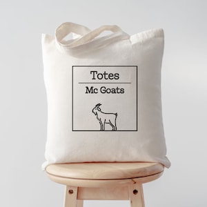 May include: A white canvas tote bag with black text that reads "Totes Mc Goats" and a black line drawing of a goat.