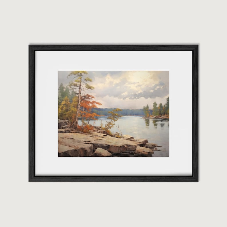May include: A framed painting of a lake scene with a rocky shoreline and trees. The sky is cloudy and the water is calm. The colors are muted and the overall tone is peaceful.