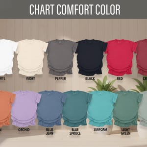Może przedstawiać: Karta kolor&oacute;w koszulek Comfort Colors. Karta przedstawia r&oacute;żne kolory, w tym biały, kość słoniowa, pieprz, czarny, czerwony, karmazynowy, pochrzyn, orchidea, niebieskie dżinsy, niebieska świerk, morska piana, jasnozielony i zatoka. U g&oacute;ry znajduje się tekst "CHART COMFORT COLOR".