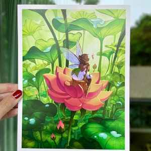 May include: A vibrant art print featuring a fairy with blue wings perched on a pink lotus flower. The fairy is surrounded by lush green lily pads and water droplets, creating a whimsical and enchanting scene.