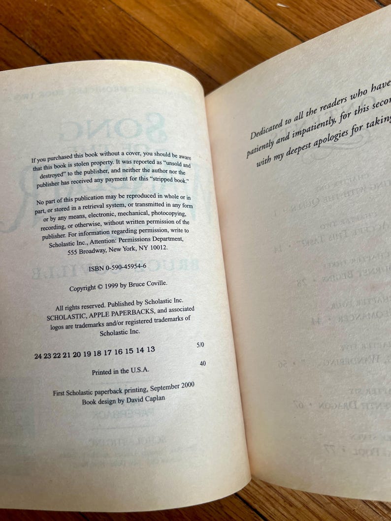 May include: Open book pages with text. The left page contains copyright information, ISBN, and publisher details. The right page has a dedication. The book is a paperback, printed in the USA.