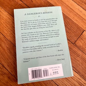 May include: A paperback book titled "A Dangerous Mission" with text on the back cover. The cover is a light teal color. The book is part of the Unicorn Chronicles series and includes a barcode and price tag.