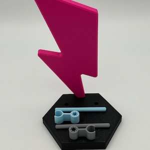3D printed pink lightning bolt shaped doll stand with a black hexagonal base