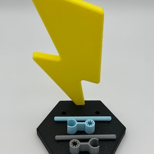3D printed black hexagonal base with a yellow lightning bolt on top doll stand