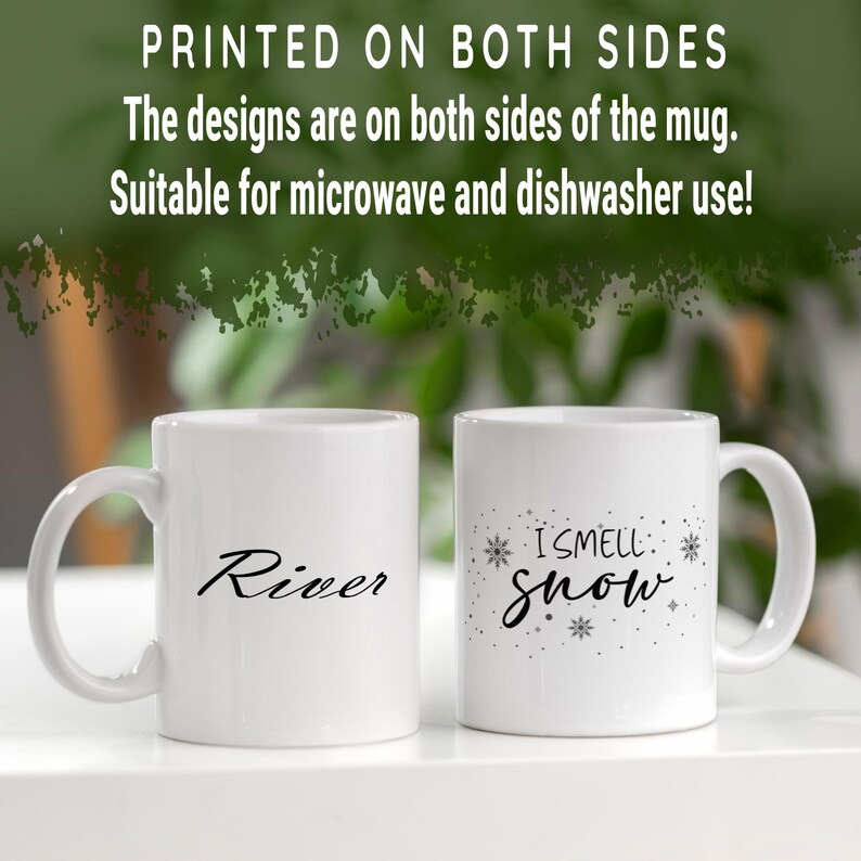 Puede incluir: Dos tazas de cer&aacute;mica blanca con texto negro. Una taza dice "River" y la otra taza dice "I smell snow" con un dise&ntilde;o de copo de nieve.