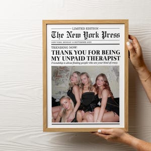 May include: A framed newspaper print with the headline "The New York Press" and the text "Thank you for being my unpaid therapist."  The print features a photo of four women in a bar.