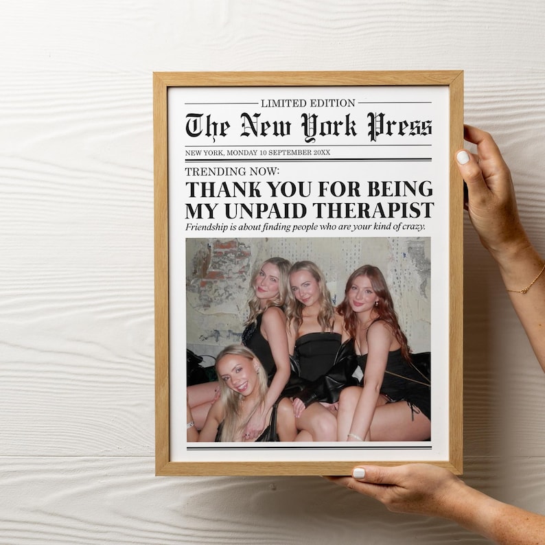 May include: A framed newspaper print with the headline "The New York Press" and the text "Thank you for being my unpaid therapist."  The print features a photo of four women in a bar.