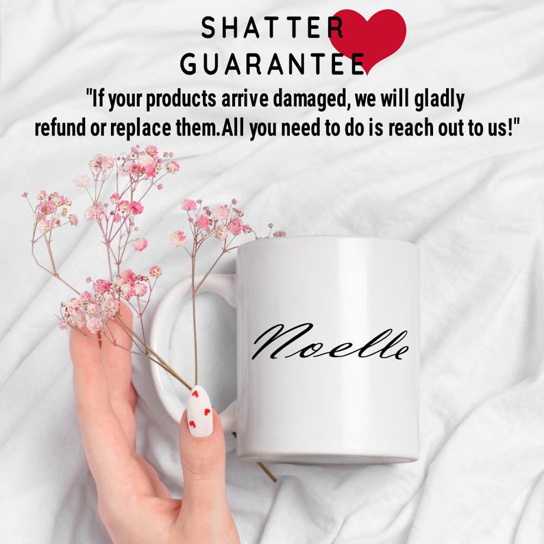 Puede incluir: Taza de cer&aacute;mica blanca con el nombre "Noelle" escrito en cursiva negra. La taza est&aacute; sobre una superficie blanca con flores rosas.