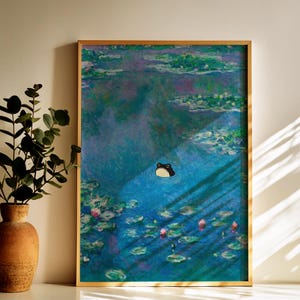 May include: A framed art print featuring a whimsical frog in a pond, inspired by Monet's water lilies. The artwork has a gold frame and depicts a blue pond with lily pads and a cartoon frog.