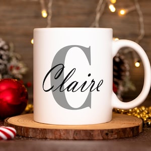 May include: White ceramic mug with a gray letter C and the name "Claire" in black script.