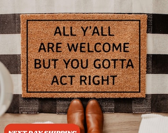 Op de afbeelding: Een bruine kokosmat met zwarte tekst die "All y'all are welcome but you gotta act right" zegt.
