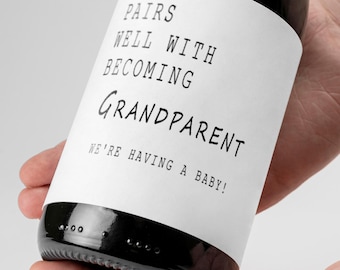 May include: A white wine bottle with a black label that reads "Pairs well with becoming Grandparent. We're having a baby!"