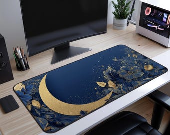 May include: A rectangular desk mat featuring a navy blue background with a gold crescent moon and floral design. The mat has gold accents and blue flowers. The desk mat is designed to protect the desk surface and provide a smooth surface for a mouse and keyboard.