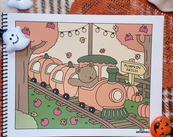 May include: A spiral-bound sketchbook featuring a cartoon illustration of a brown bear driving a pumpkin-shaped train through a pumpkin patch. The scene includes autumn trees, falling leaves, string lights, and a sign labeled PUMPKIN PATCH.