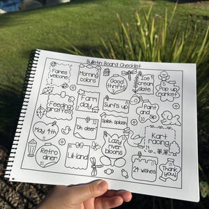 May include: A black and white spiral-bound notebook with a "Bulletin Board Checklist" title. The checklist includes hand-drawn illustrations and text such as "Faries welcome", "Morning colors", "Good thrifts", "Retro diner", and "24 wishes".