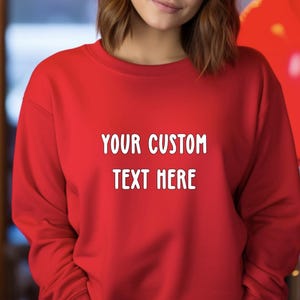May include: Red sweatshirt with the text "YOUR CUSTOM TEXT HERE" printed in white on the front.
