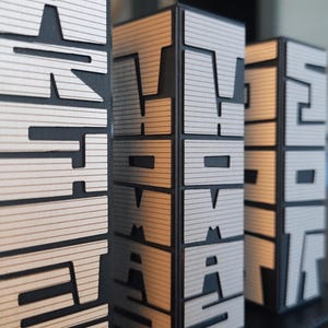 May include: Three black and silver decorative towers with the words "START", "WORK", and "STOP" spelled out on each tower.