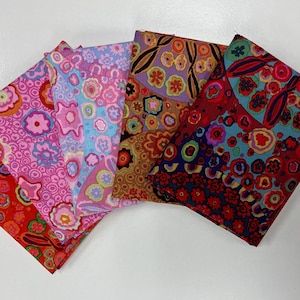 May include: Five fabric squares with a colorful, abstract pattern of circles, dots, and swirls. The fabrics are in shades of pink, blue, red, brown, and purple.