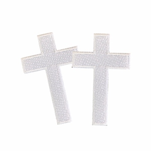Puede incluir: Dos parches bordados de cruz blanca. Las cruces son simples y de diseño tradicional.