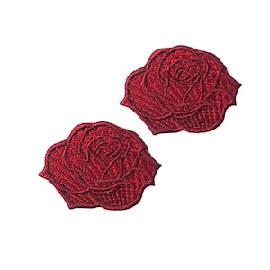 May include: Two red embroidered rose patches. The roses are detailed and have a vintage look.