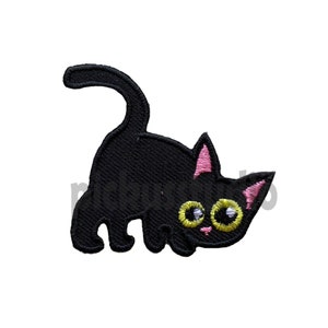May include: Black embroidered iron-on patch of a cartoon cat with pink ears and yellow eyes. The cat is looking to the right and has its tail curled around its body.