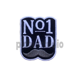 Può includere: Toppa ricamata in bianco e nero con il testo "NO 1 DAD" e un baffo grigio sotto.