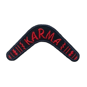 May include: A black fabric boomerang patch with red embroidered text that reads "KARMA".