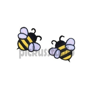 May include: Two embroidered bee patches with black bodies, yellow and black striped abdomens, and white wings.