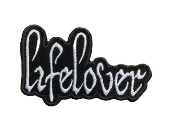 May include: Black embroidered iron-on patch with white cursive lettering that reads "lifelover".
