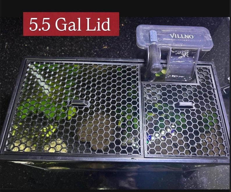 May include: A black aquarium lid with a honeycomb pattern, featuring a built-in filter system. The lid is labeled "5.5 Gal Lid" in white text on a red background. A clear plastic filter is attached to the lid, with the brand name "VILLNO" visible.