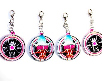 May include: Four circular keychains with silver lobster claw clasps. Two feature a black spider graphic with the text MCR and DANGER DAYS. Two feature a colourful graphic with the text MY CHEMICAL ROMANCE DANGER DAYS in pink and white lettering.